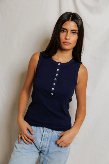 Woman in a navy sleeveless top with buttons