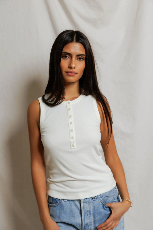 Woman wearing a white sleeveless top with buttons