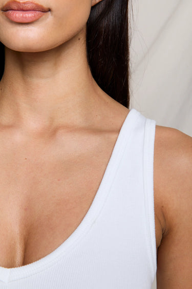 Woman wearing a white ribbed tank top