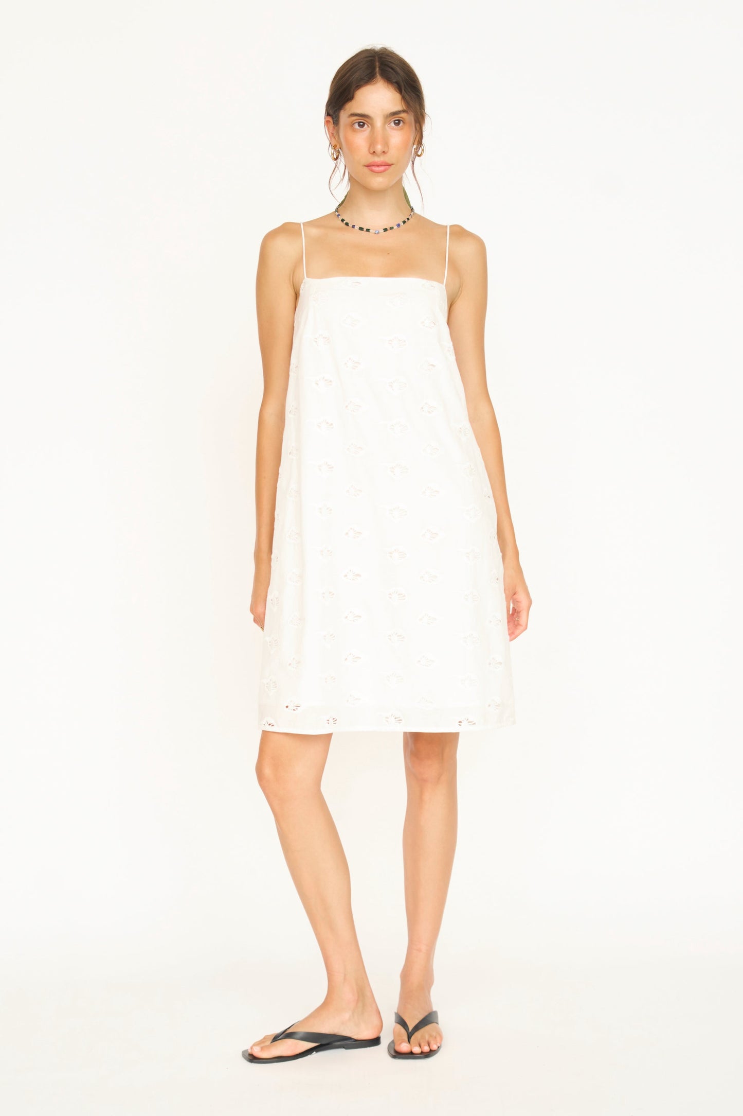 Woman in a white eyelet mini dress