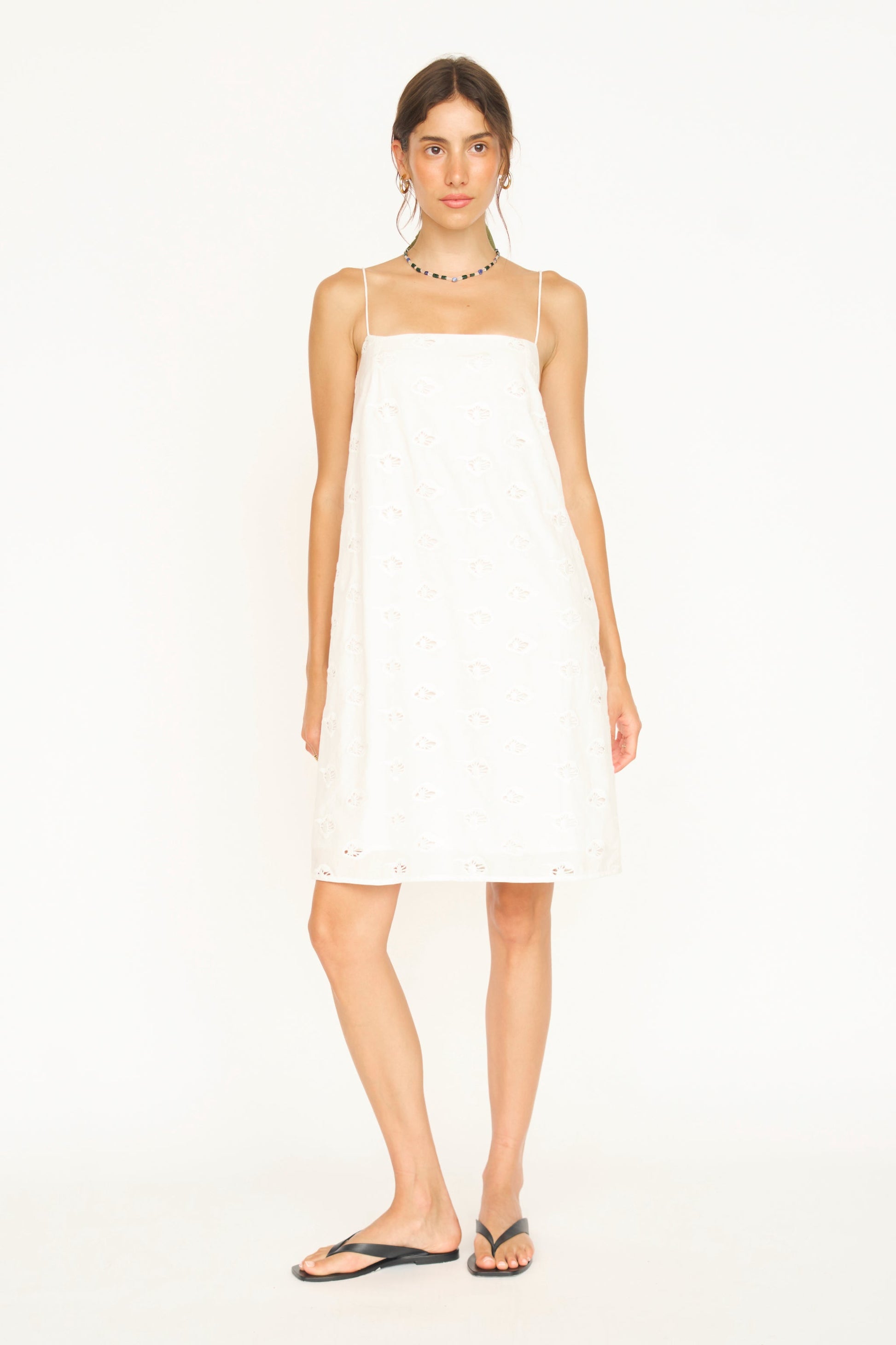 Woman in a white eyelet mini dress