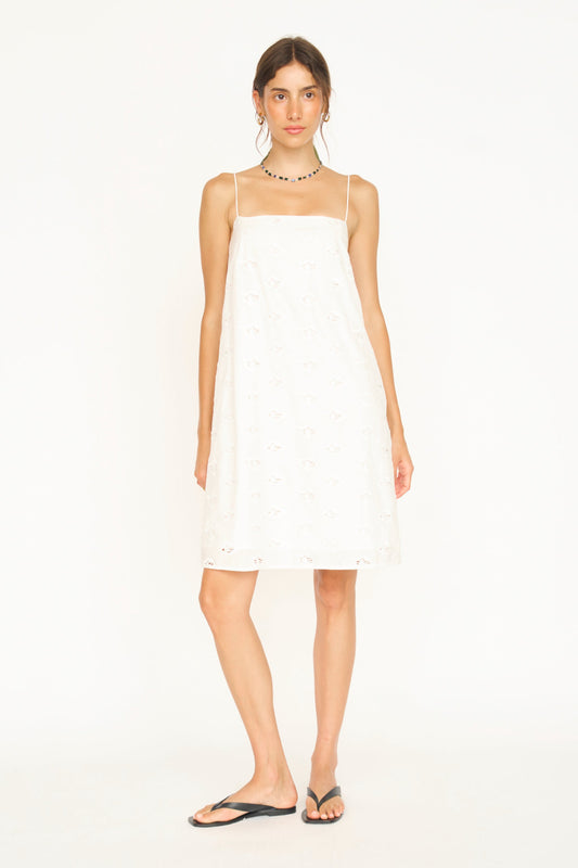 Woman in a white eyelet mini dress