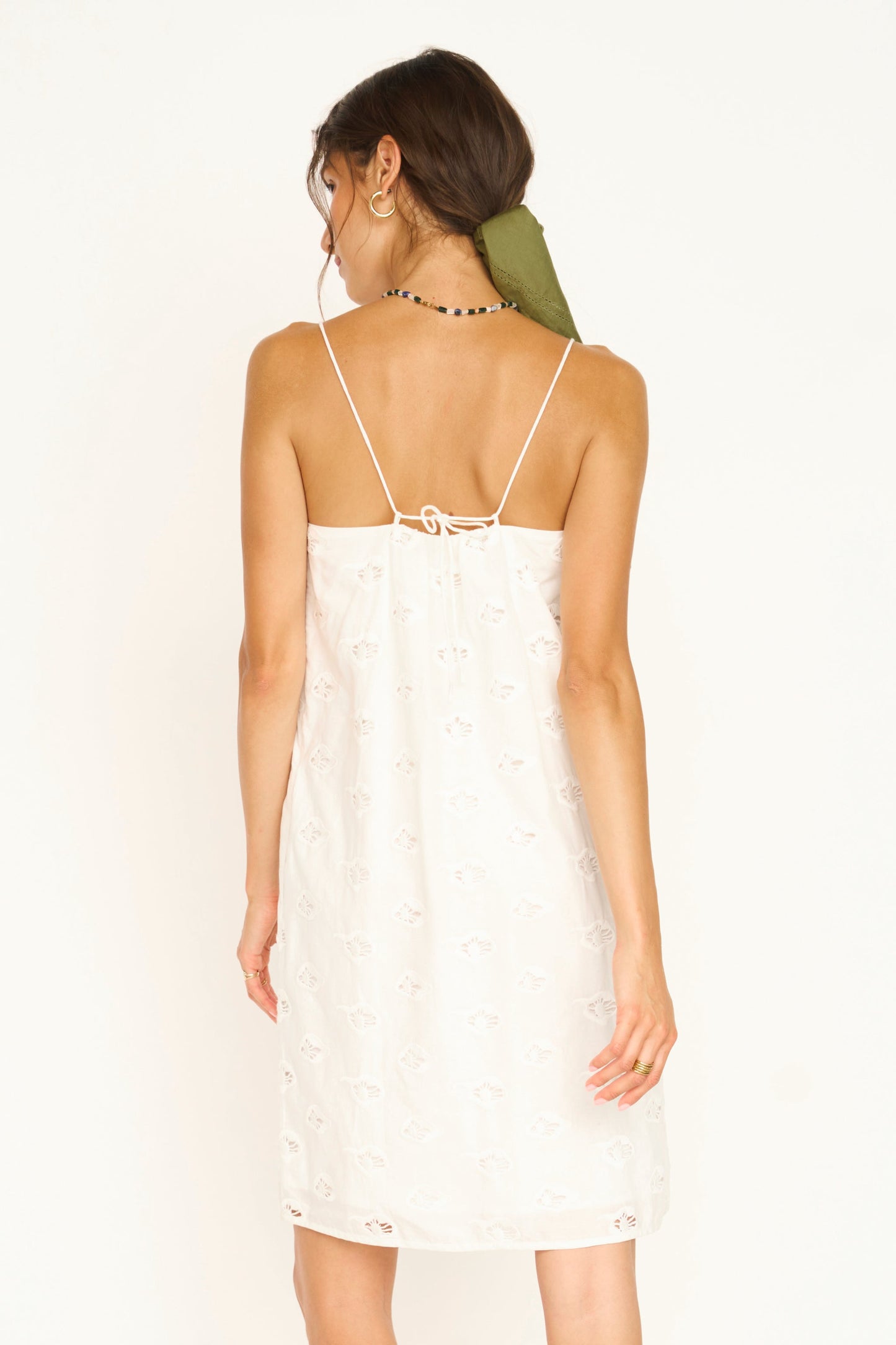 Woman in a white eyelet mini dress