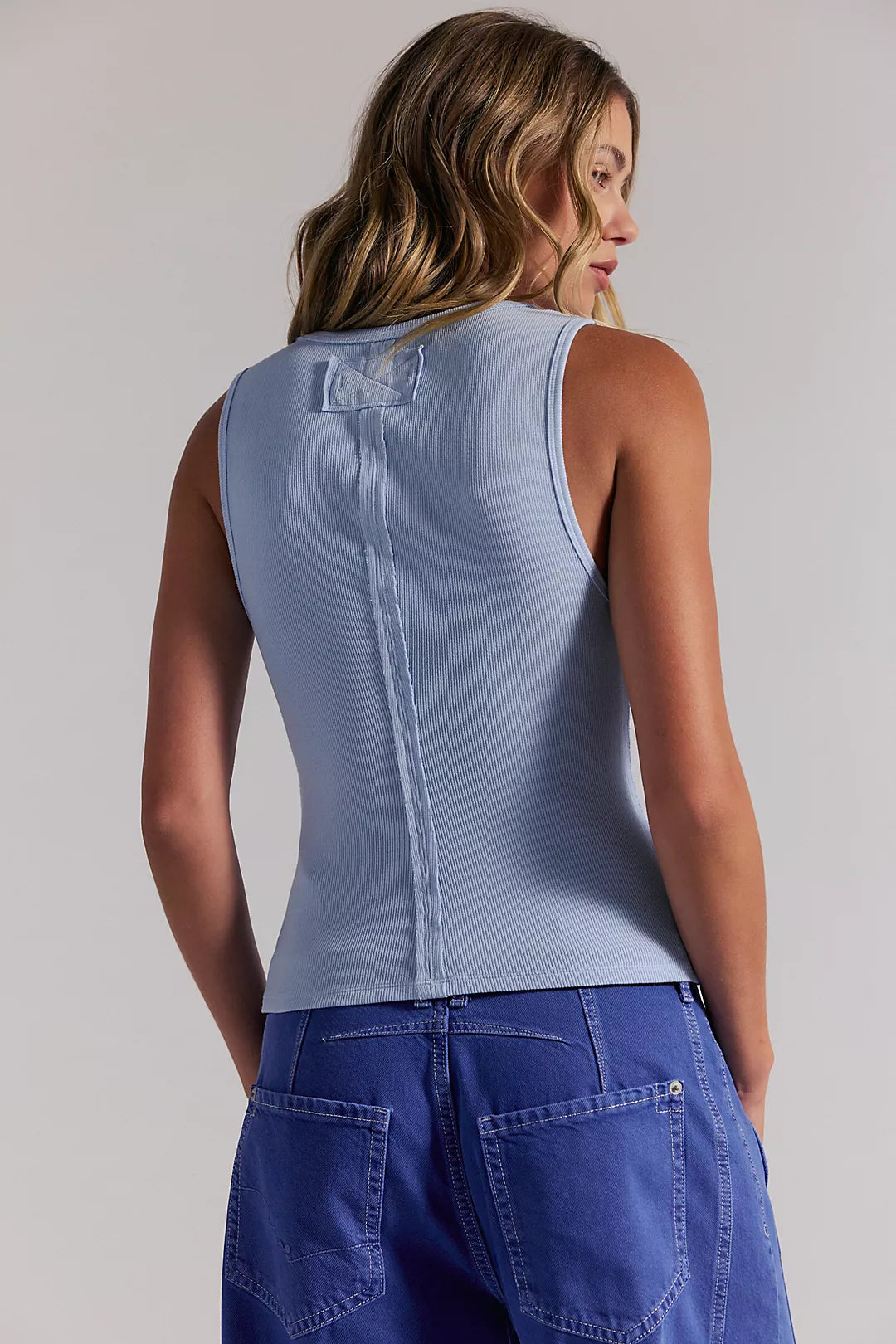 Woman wearing a light blue sleeveless shirt 