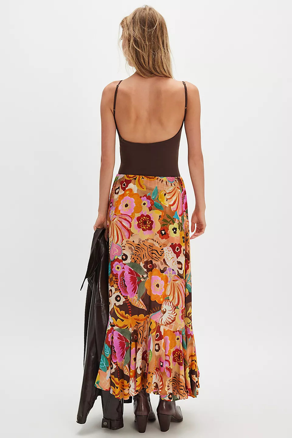 Woman wears caramel-colored maxi skirt with boots, featuring lightweight fabric ideal for casual or semi-formal wear.